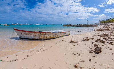 Old boats and modern yachts on a beach in Punta Cana, Dominican