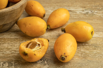 Loquat fruits on wooden background. Eriobotrya japonica, Chinese plum, nespolo. 