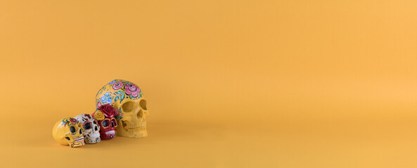 Fototapeta na wymiar Day of the Dead, colorful skulls on yellow background