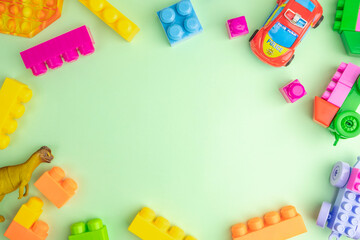 Kid toys laid out in the frame over mint green background.