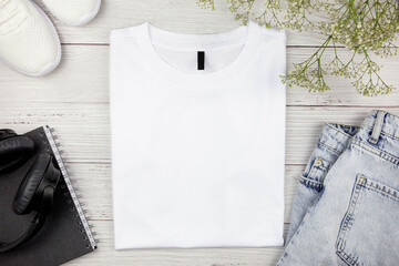 White womens cotton Tshirt mockup with flowers, jeans, sneakers, paper notebook and black...