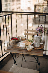breakfast outside on the summer balcony. coffee table with breakfast ingredients. wood table with snacks and coffee.
