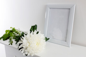 Large white chrysanthemum and photo frame on white table