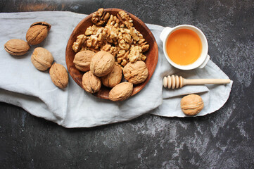 Walnut in wooden bowl on black background with copy space.Top view. Wooden plate with walnut on black background. Space for text