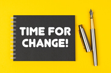 On a yellow background lies a pen and a black notebook with the inscription - Time For Change