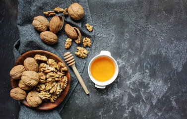 Walnut in wooden bowl on black background with copy space.Top view. Wooden plate with walnut on black background. Space for text