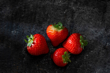 strawberries on a dark background studio low key dark mood light 