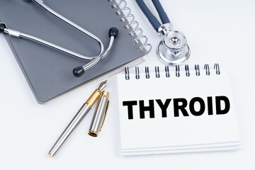 On the table are a stethoscope, a pen and a notebook with the inscription - THYROID