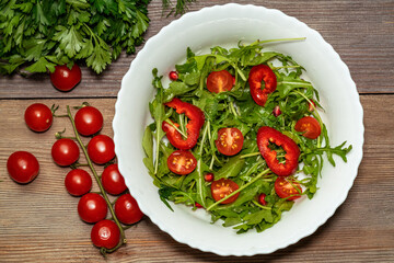 Rosemary salad, Arugula, tomatoes, peppers in a white plate
