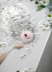 Spa procedure in the bathroom with a bomb and flowers