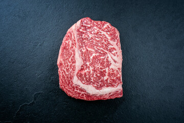 Raw dry aged wagyu cutlet steak cut offered as top view on black background with copy space