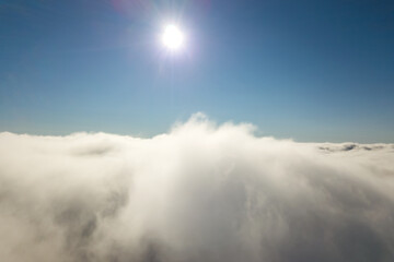 Aerial view from above of white puffy clouds.