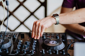 DJ's hands. A mixing remote to collect signals and play.