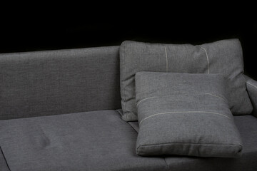 Gray pillows on the couch. Sofa on black background. Soft furniture.