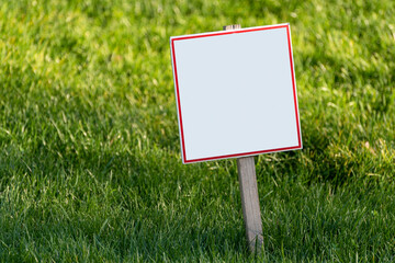 Blank white plate on lawn background. Place for your text. Copy space