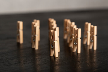 Set wooden clothespins stand on dark background. People group meeting concept.