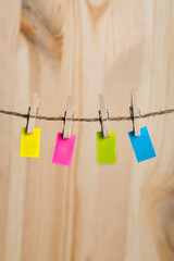 Multicolored paper notes hang with clothespins on rope. Copy space. Place for your text. Vertical frame
