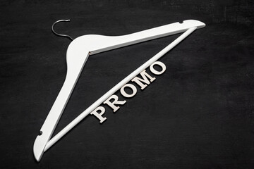 White Hanger and Promo Inscription on Black Background. Shares, discounts, Black Friday.