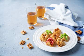 Multicolored baklava, Oriental sweetness on a plate with tea