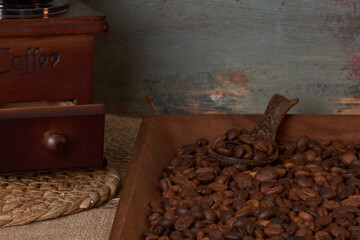 Coffee beans and grinder on table with rustic background