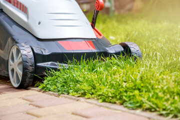 Lawn mower in front of a mown green lawn