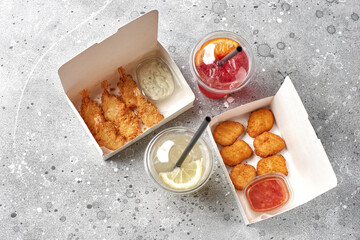 food delivery, takeaway food with fried shrimps in batter and hot chicken nuggets.