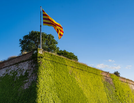 Catalan flag flying over the walls of the Montjuïc Castle in Barcelona, Spain.