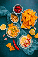 Homemade spicy humus with pomegranate seeds, chilli and chickpeas tortilla chips