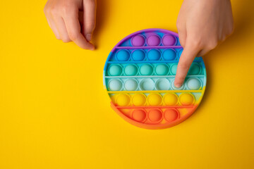 Child is playing trendy popular board game anti-stress toy pop it (popit or simple dimple).