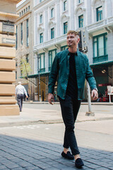 Young caucasian man walking on the street 