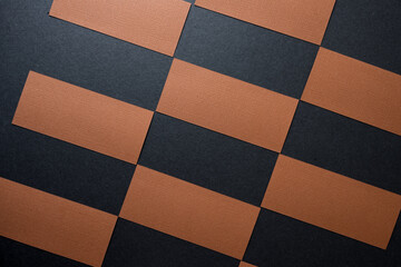 tiles of rectangular pieces of brown construction paper arranged in a checkered pattern on black