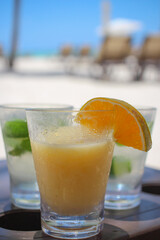 mojito i drink na soku owocowym z pomarańczą na tle plaży na karaibach - obrazy, fototapety, plakaty