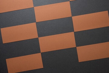 brown construction paper rectangles arranged in a checkered pattern on dark grey board -...