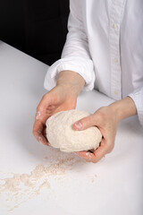 Women's hands knead dough to make bread