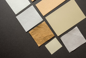 pieces of yellow-ochre and unbleached white paper arranged on a grey board - photographed from above in a flat lay style
