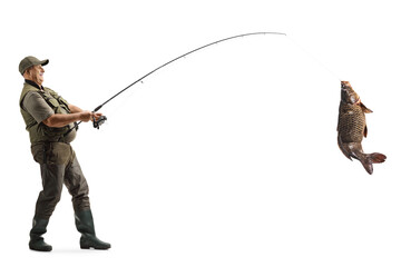 Full length profile shot of a mature fisherman catching a big carp fish with a fishing pole - obrazy, fototapety, plakaty