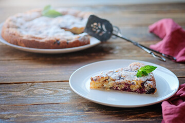 Piece of homemade simple pie with fresh red raspberries and black mulberry on a dark wooden rustic background. Summer berry dessert. Sugar powder.