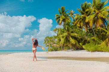 Beach vacation woman sunbathing relaxing on remote island in Rangiroa atoll, Tuamotu islands,...