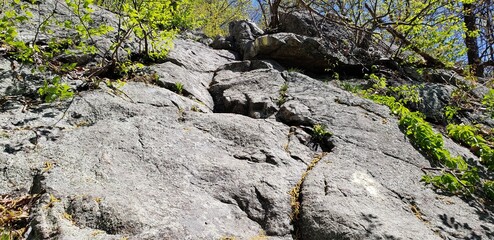 Rock scramble on the yellow blazed Suffern-Bear Mountain hiking trail in New York's Harriman State Park. The blaze is painted on the rockface as the trail leads steeply up.