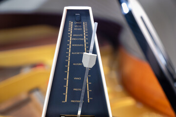 Metronome with pendulum to keep rhythm and tempo for piano, classical music,  musicians - close-up...