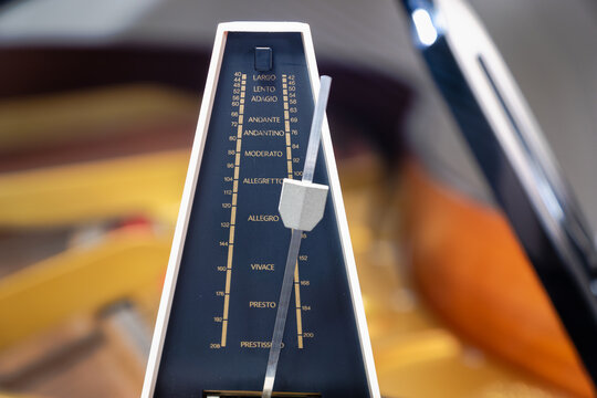 Metronome with pendulum to keep rhythm and tempo for piano, classical music,  musicians - close-up with selective focus