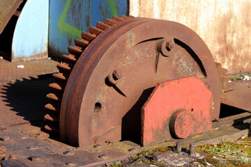Closeup of large vintage rusted old railway turntable or wheelhouse cogwheel mounted on side of railroad tracks used for turning rolling stock or locomotives or railroad cars or coaches or private rai © hecos