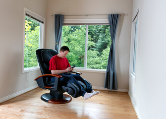 Mature man selecting program on home massage chair