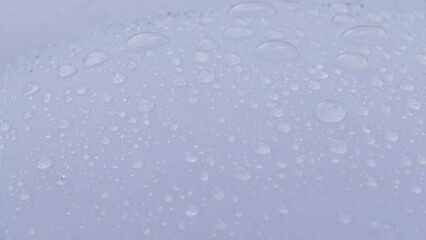reflecting water drops on white glass surface