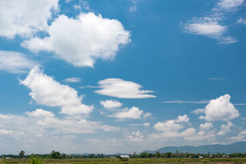 The white clouds have a strange shape and country side.Cloudy and blue sky.