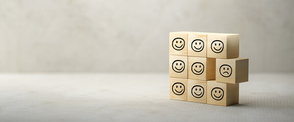 stacked cubes with smiley symbols in front of a concrete background