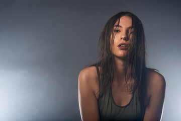 Photo with a smokey background of a confident young sporty girl with wet hair looking at the camera