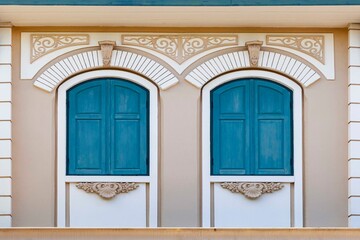 Antique European blue arched wooden windows and patterned cement walls