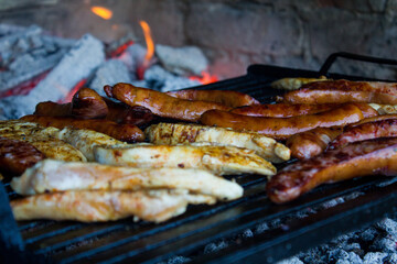 Chicken and sausage on grill and fire