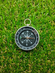 Compass on grass background. Travel concept.Compass with fresh green grass and copy space.